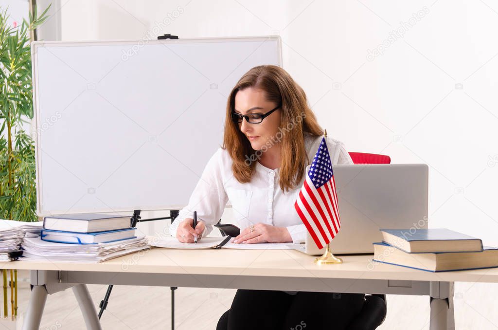 Female english language teacher in front of whiteboard 