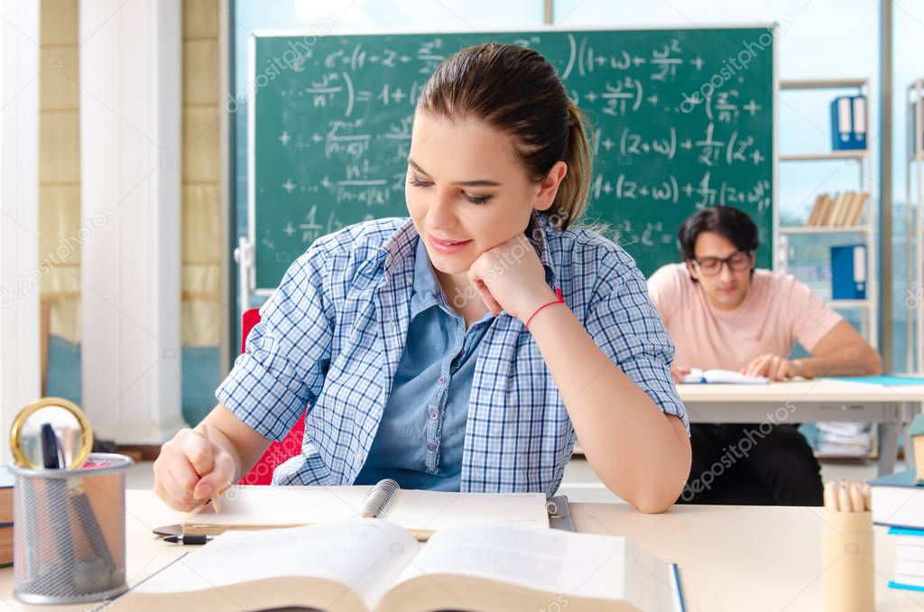 Young students taking the math exam in classroom 