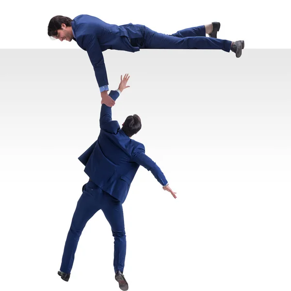 Businessman offering helping hand to falling colleague — Stock Photo, Image