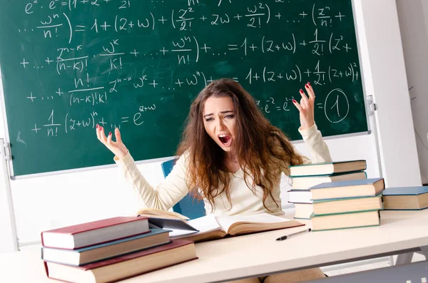 Young female math teacher in front of chalkboard
