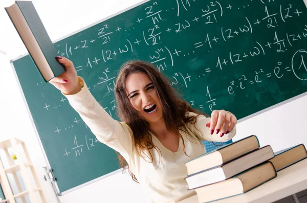 Jonge vrouwelijke wiskundeleraar voor schoolbord — Stockfoto