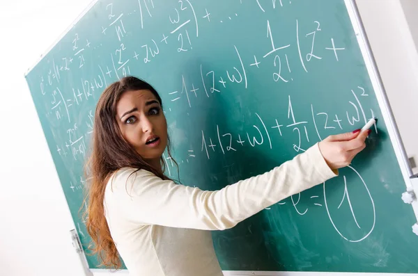 Joven profesora de matemáticas delante de pizarra — Foto de Stock