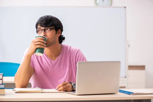 Giovane studente maschio seduto in classe — Foto Stock