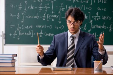 Genç erkek matematik öğretmeni sınıfta 