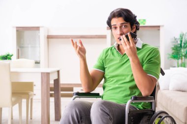 Tekerlekli sandalyedeki genç yakışıklı adam. 