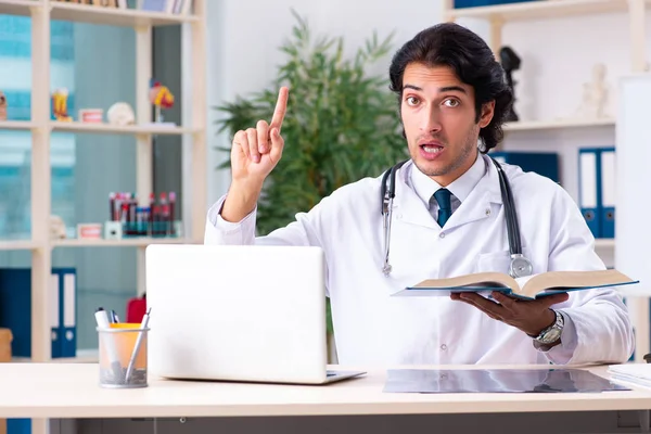 Jonge knappe arts werkzaam in een kliniek — Stockfoto