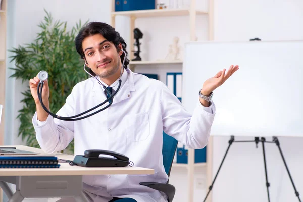 Giovane bel dottore che lavora in clinica — Foto Stock