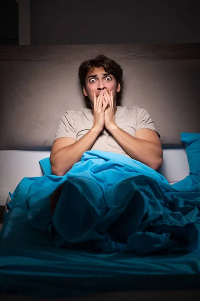 Jonge man bang in zijn bed nachtmerries — Stockfoto