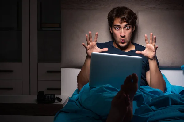 Mann arbeitet nachts am Laptop im Bett — Stockfoto