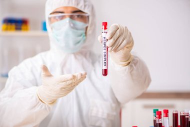 Genç yakışıklı laboratuvar asistanı hastanede kan örnekleri test ediyor. 