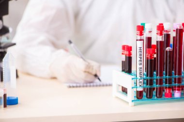 Genç yakışıklı laboratuvar asistanı hastanede kan örnekleri test ediyor. 