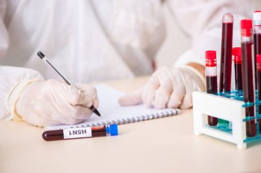 Genç yakışıklı laboratuvar asistanı hastanede kan örnekleri test ediyor. 