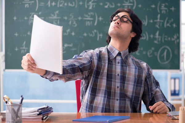 Joven profesor de matemáticas divertido delante de pizarra — Foto de Stock