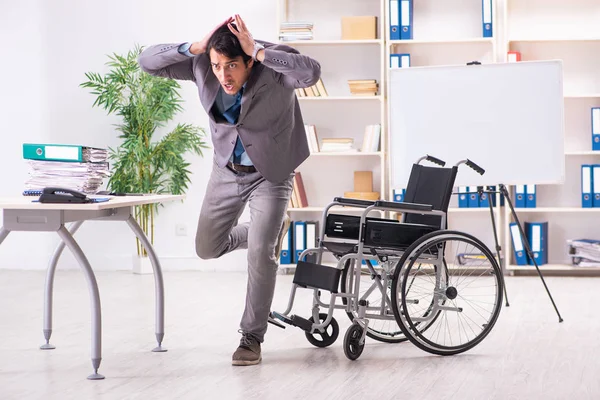 Joven empleado guapo en silla de ruedas en la oficina —  Fotos de Stock