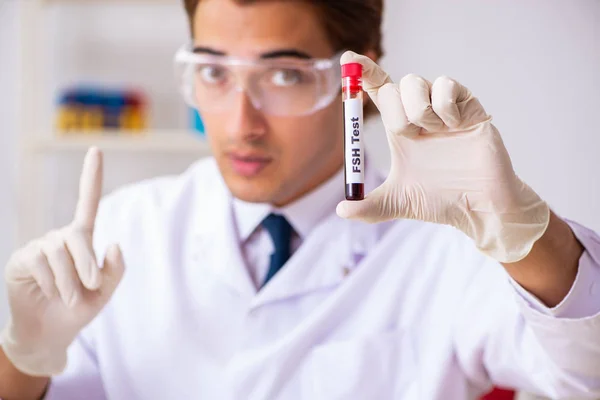 Asistente de laboratorio joven guapo analizando muestras de sangre en el hospital — Foto de Stock