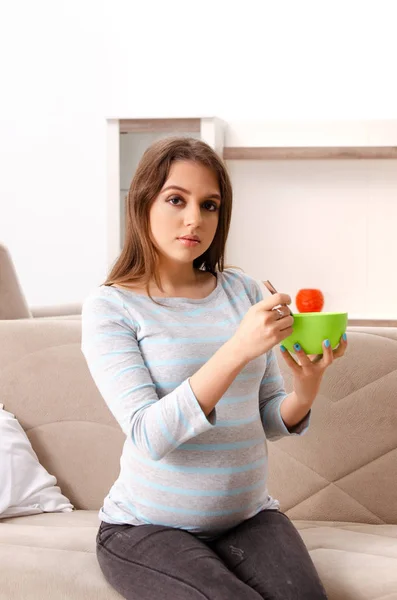 Young pregnant woman sitting on the sofa at home — Stock Photo, Image