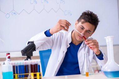 Laboratuarda oturan genç kimyager 