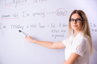 Young female english language teacher standing in front of the b clipart