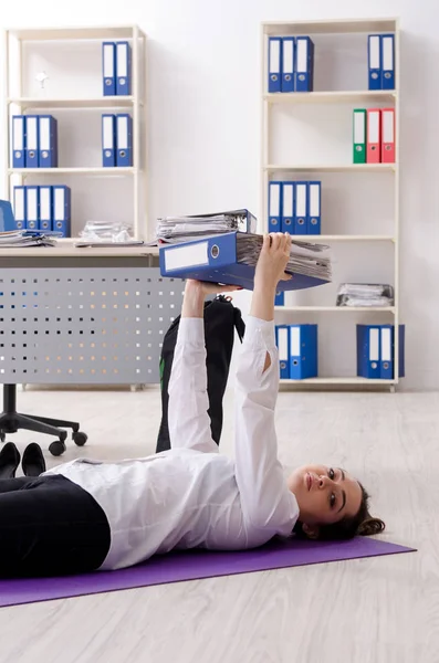 Сотрудница, занимающаяся спортивными упражнениями в офисе — стоковое фото