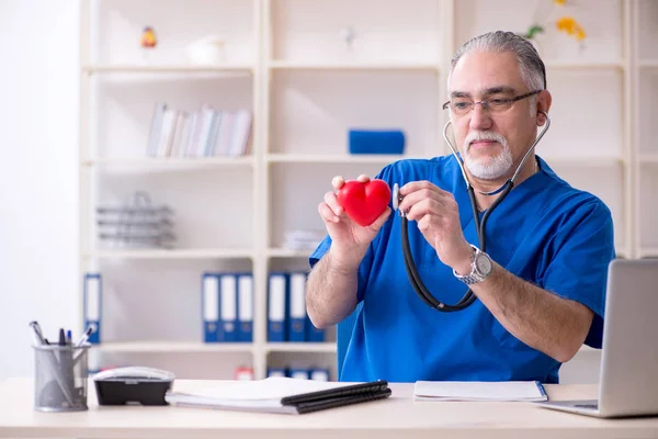 Weißbärtiger alter Arzt arbeitet in Klinik — Stockfoto