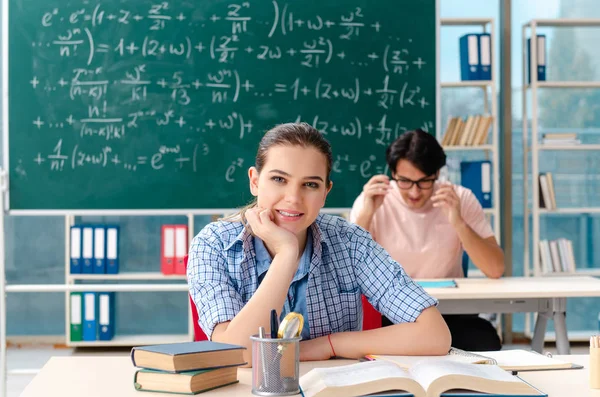 Jovens estudantes fazendo o exame de matemática em sala de aula — Fotografia de Stock