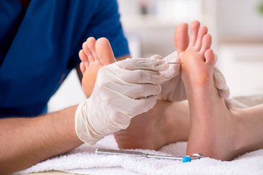 Podiatrist treating feet during procedure clipart