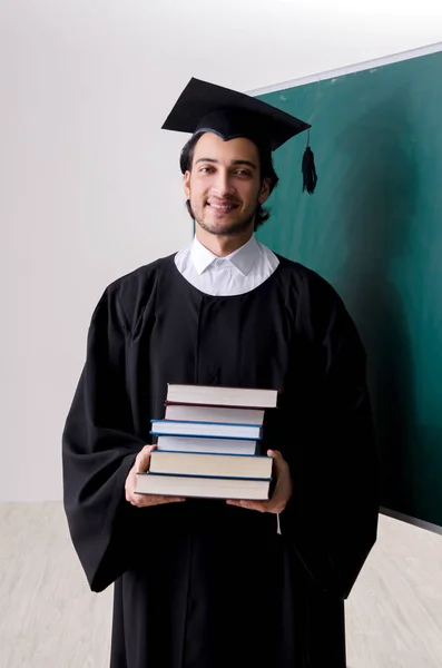 Estudante graduado na frente do quadro verde — Fotografia de Stock