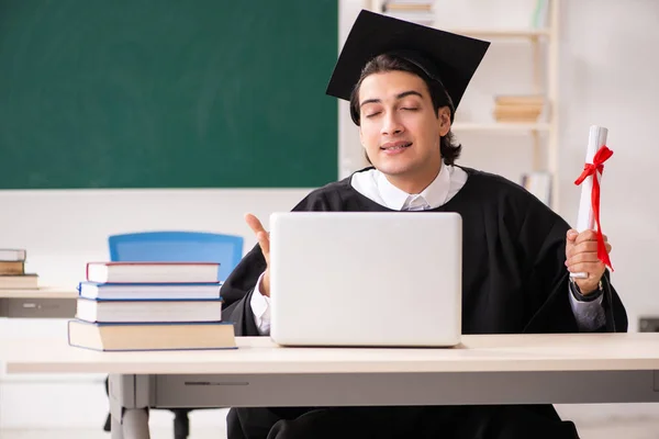 Estudante graduado na frente do quadro verde — Fotografia de Stock