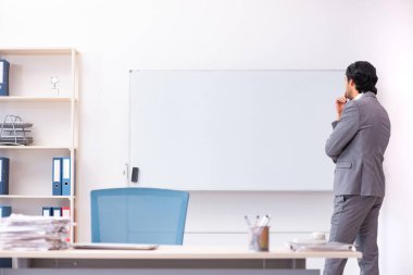 Beyaz tahta önünde duran genç yakışıklı işadamı 