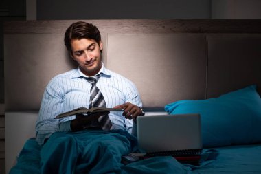Yorgun işadamı gece fazla mesai yapıyor.