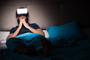 Genç adam, gece yatakta ile bilgisayar oyunu oynamak