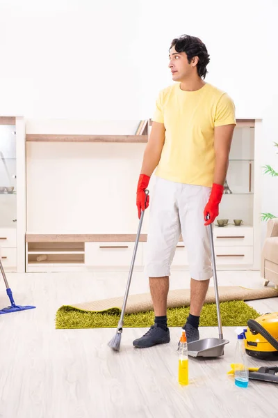 Молодой красивый мужчина, выполняющий работу по дому — стоковое фото