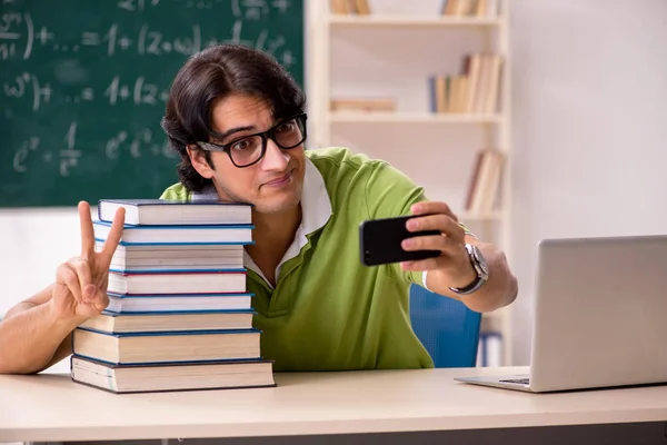 Handsome student in front of chalkboard with formulas — Stock Photo, Image