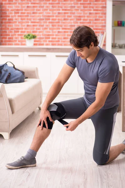 Joven hombre guapo haciendo ejercicios deportivos en casa — Foto de Stock