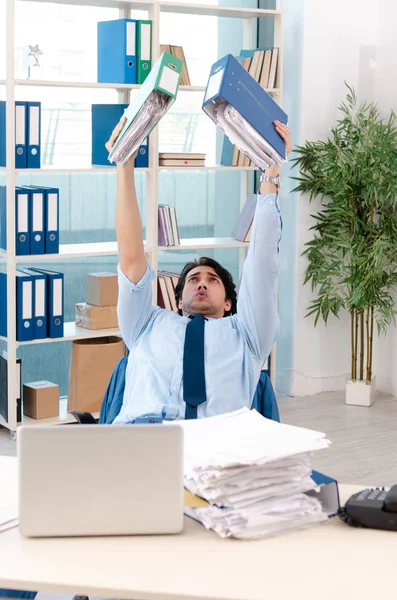 Young handsome male employee with too much work in the office — Stock Photo, Image