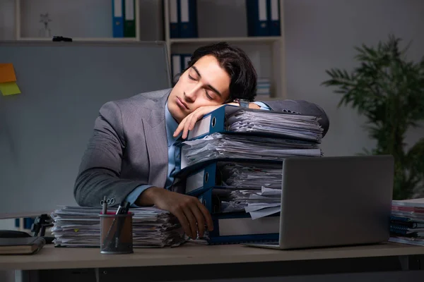 Young male employee working late at office
