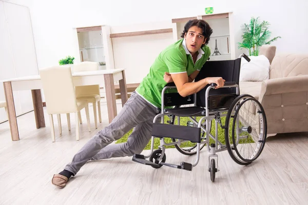 Jovem homem bonito em cadeira de rodas em casa — Fotografia de Stock