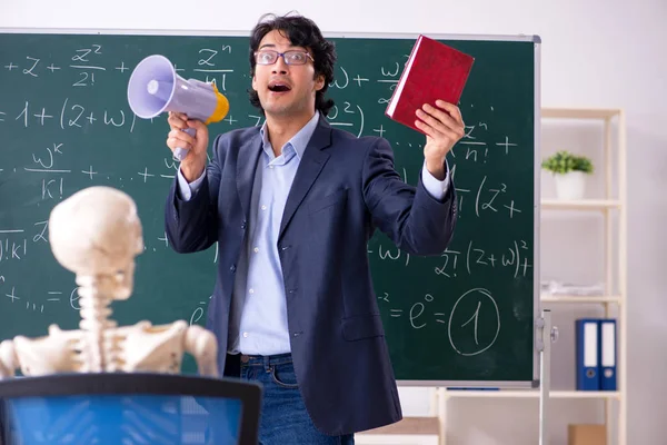 Jonge mannelijke wiskunde-onderwijzer en student skelet — Stockfoto