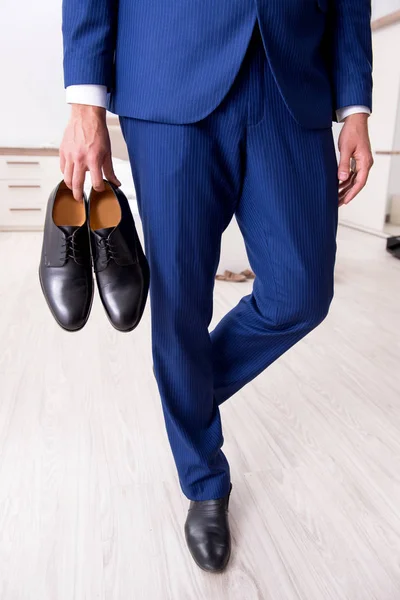 Young handsome businessman choosing shoes at home — Stock Photo, Image