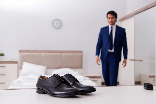 Молодой привлекательный бизнесмен выбирает обувь дома — стоковое фото