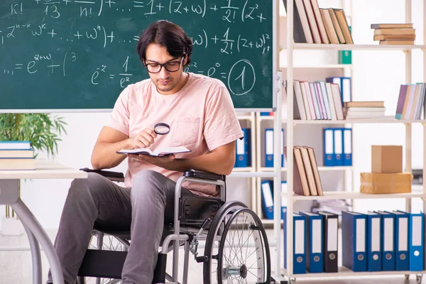 Jonge knappe man in rolstoel voorkant schoolbord — Stockfoto