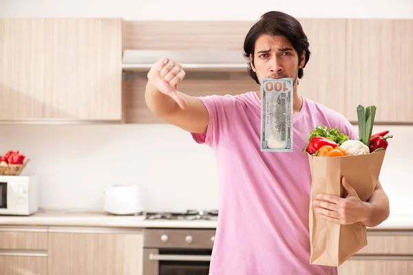 Jovem homem bonito com legumes na cozinha — Fotografia de Stock