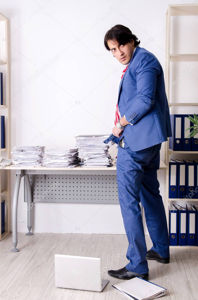 Young businessman employee unhappy with excessive work 