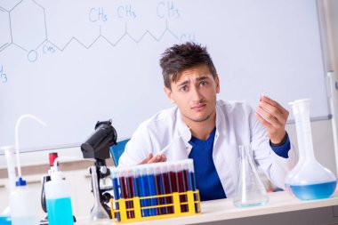 Laboratuarda oturan genç kimyager 