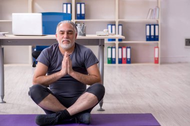 Ofis egzersizleri yapıyor yaşlı adam çalışan beyaz sakallı 