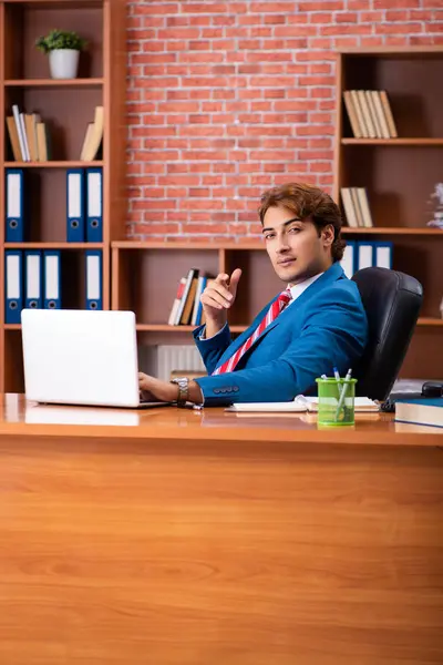 Jovem e bonito empregado sentado no escritório — Fotografia de Stock