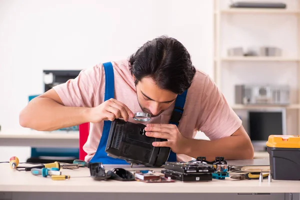 Jovem empreiteiro do sexo masculino reparando computador — Fotografia de Stock