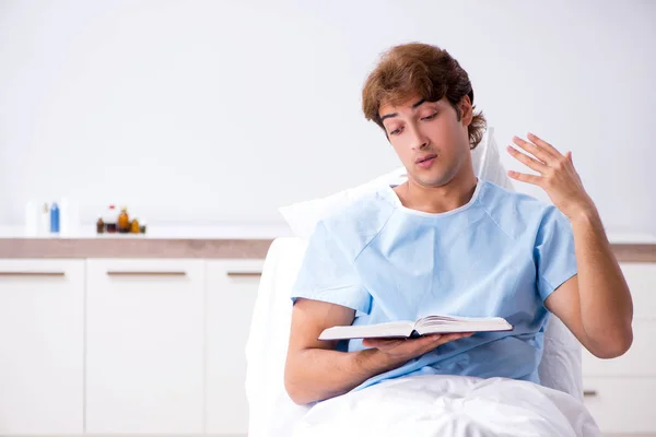 युवा पुरुष रोगी अस्पताल में सोफे पर पड़े — स्टॉक फ़ोटो, इमेज