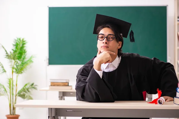 Estudante graduado na frente do quadro verde — Fotografia de Stock