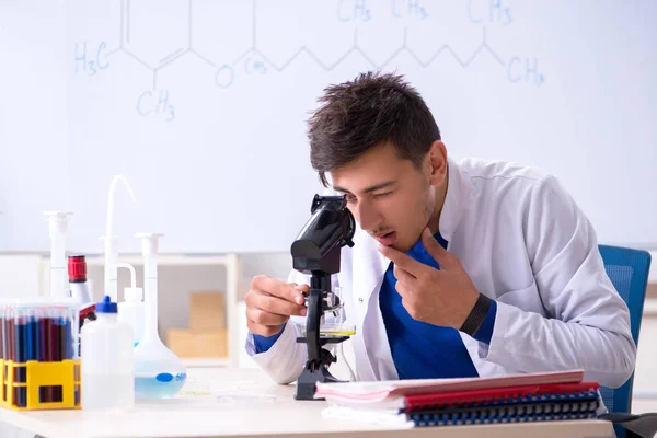 Joven químico sentado en el laboratorio —  Fotos de Stock